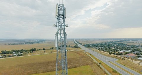 Aerial view on tower of cell phone antenna road with transportation and blue sky. Shoot from drone. 4K video