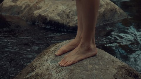 girl walks barefoot in the woods in a cloak