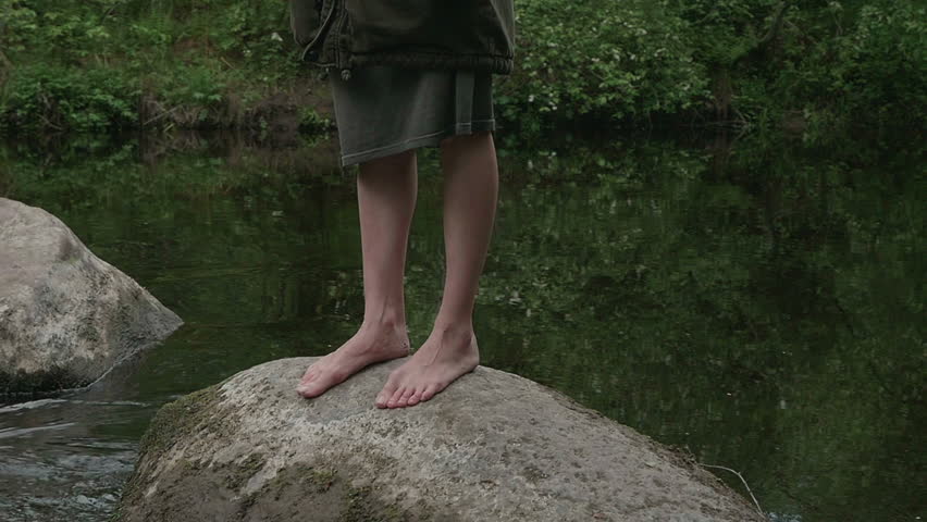 girl walks barefoot in the woods in a cloak