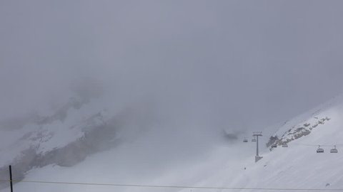 MOUNT TITLIS, SWITZERLAND: May 02, 2016: 4k footage of View at the mount Titlis peak in foggy misty weather, tourist enjoying in snow.