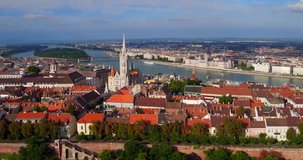 Aerial video taken by a drone shows the Buda Castle and the Matthias Church overlooking the river Danube in Budapest sunset 