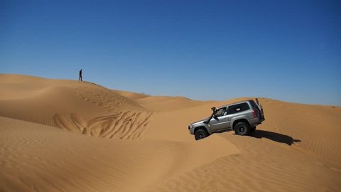 SAHARA DESERT, TUNISIA - CIRCA OCTOBER 2015: an  off road car drives on a dune in the Sahara desert and gets stuck in the sand.