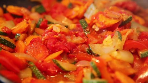 cooking vegetables in a frying pan with a wooden spoon (close up)