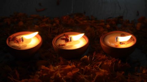 Petals falling behind Diyas or lamps lit up for Diwali 'Festival of light', the most important ancient Hindu festival celebrated signifying victory of light over darkness Adlı Stok Video