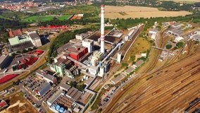 Camera flight over modern combined heat and power plant. Fuming chimney with sulphur removal unit. Heavy industry from above. Power and fuel generation in Czech Republic, European Union. 