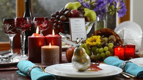 Colorful rustic style Thanksgiving table with fruit, candles, and cornucopia centerpiece in front of a garden window on a rainy day, slow zoom in.  - Powered by Shutterstock - Get 15% off with code: PIKWIZARD15