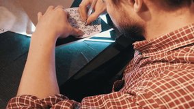 Bearded man in plaited shirt draws mandala geometrical pattern on a lightbox using copy paper - Powered by Shutterstock - Get 15% off with code: PIKWIZARD15