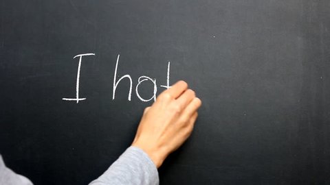 Writing "I Hate You". Writing "I hate you" by chalk on blackboard.