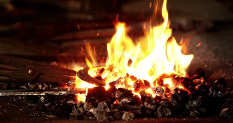 Close-up of blacksmith heating a horseshoe in fire 4k