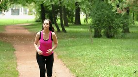 A young woman runs and drinks water in a beautiful green park in slow motion, The Slow Motion of  Running In a Nature, Slow Motion Video Clip