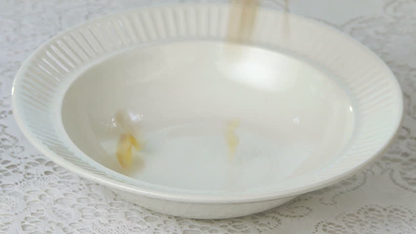 Pouring breakfast cereal into bowl