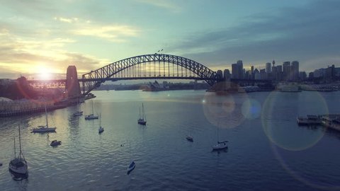 4k aerial footage b-roll of Sydney Harbour Bridge during sunrise at summer. Cinematic look and lens flare effect.