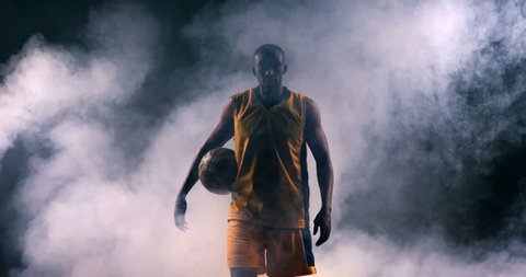 Determined sportsman walking with basketball in basketball court 4k