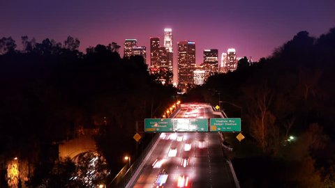 Downtown Los Angeles skyline and freeway city traffic at night. Timelapse.