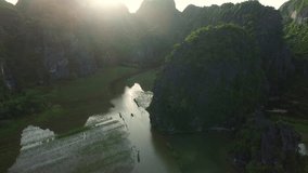 A suggestive aerial footage, near the rocks, above a typical asian river landscape at the sunset, Vietnam, Tam Coc