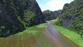 A suggestive aerial footage, near the rocks, above a typical asian river landscape in a beautiful day, Vietnam, Tam Coc