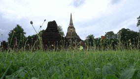 Dolly shot of field, grass blown in the wind. Sukhothai and Jedi, cloudy sky. Dolly Slider Shot
