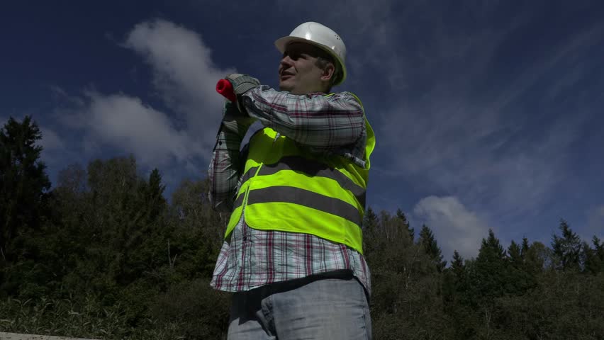 Road construction worker with traffic cone on shoulder