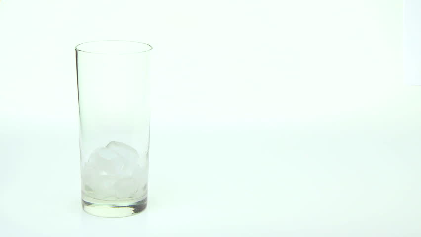 Orange Juice being poured into tall glass with ice