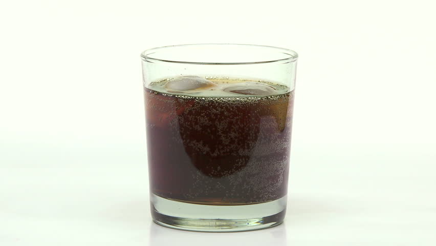 Cola pop being poured into a glass with ice