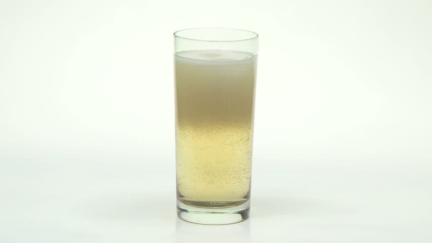 Ginger Ale pop being poured into a glass with ice