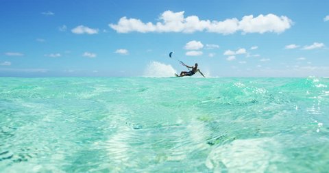 Young man kitesurfing in tropical blue ocean