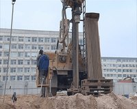 Industrial construction machine drill ground borehole for foundation. Workers supervise process 