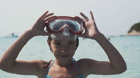 Little girl in mask dive into the water in the sea. 4K