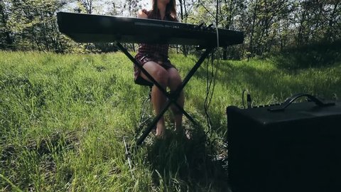 girl in the forest plays the synthesizer and sings