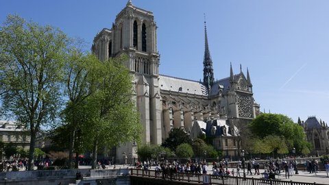 PARIS, FRANCE: May 05, 2016: 4k footage of Cathedral Notre Dame de Paris on square Parvis Notre-Dame - place Jean-Paul-II with lot of people at noon.