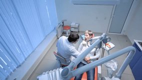 Dentist carrying out an examination of his patient's oral cavity, crane shot