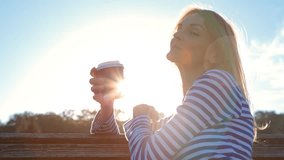 High quality 10bit footage of Beautiful Girl Drinking Coffee Enjoying the Sun in City Park at sunset. Made from 14bit RAW.