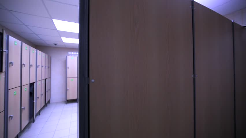 Interior of the room with many lockers and benches in sport club.
