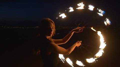 Emotional performance of a beautiful young blonde woman with flaming torches in slow motion Video Stok