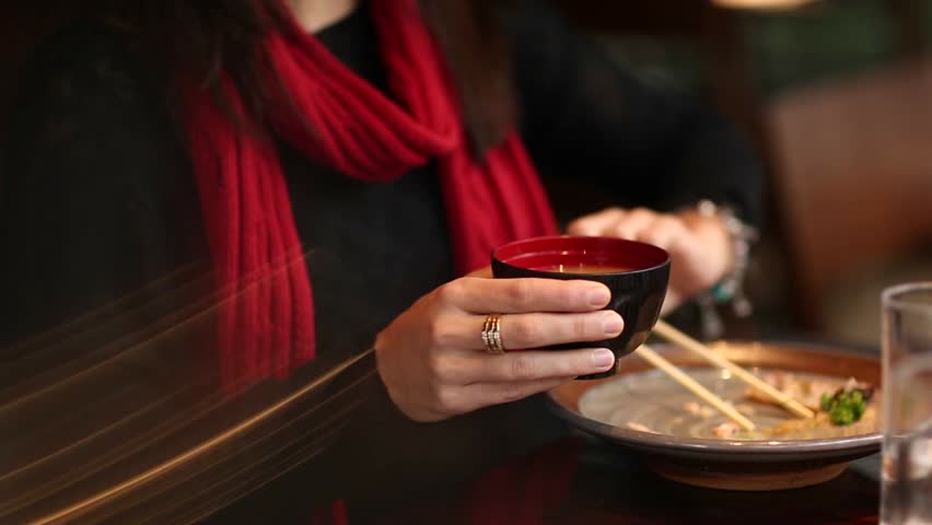 Young woman stirring noodle soba with sticks