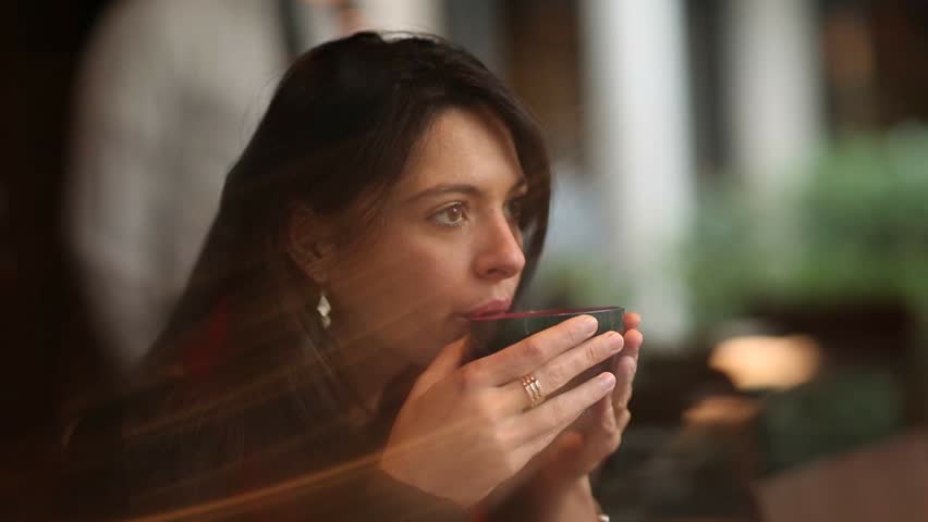 Young woman sipping from hot soup while listening to conversation | Shutterstock HD Video #19691791