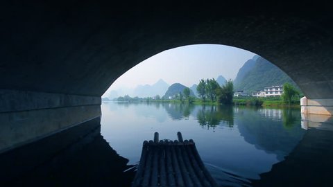 Bamboo raft flowing through an idyllic rural landscape