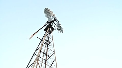 Close up of a farm windmill against skies. 4K. UHD