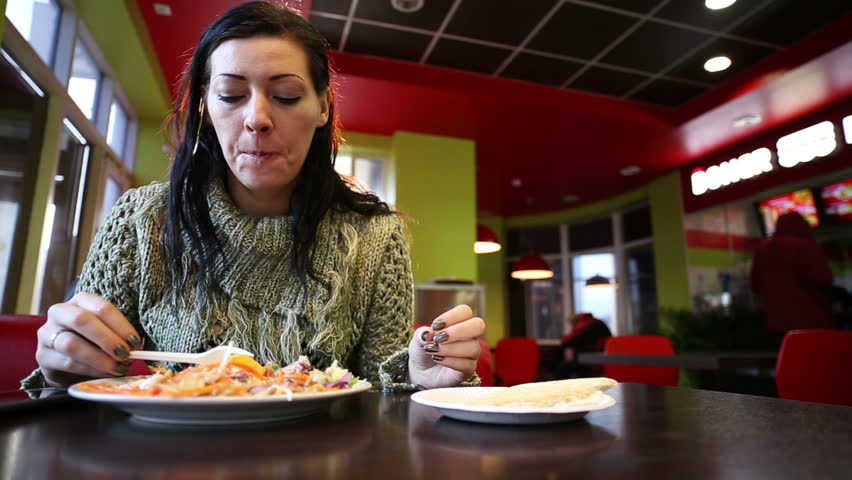 Woman Eating In The Cafe And Surfing Smart Phone