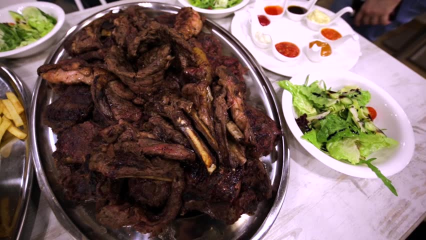 Close view of fried potato and delicious meat steaks in a restaurant.