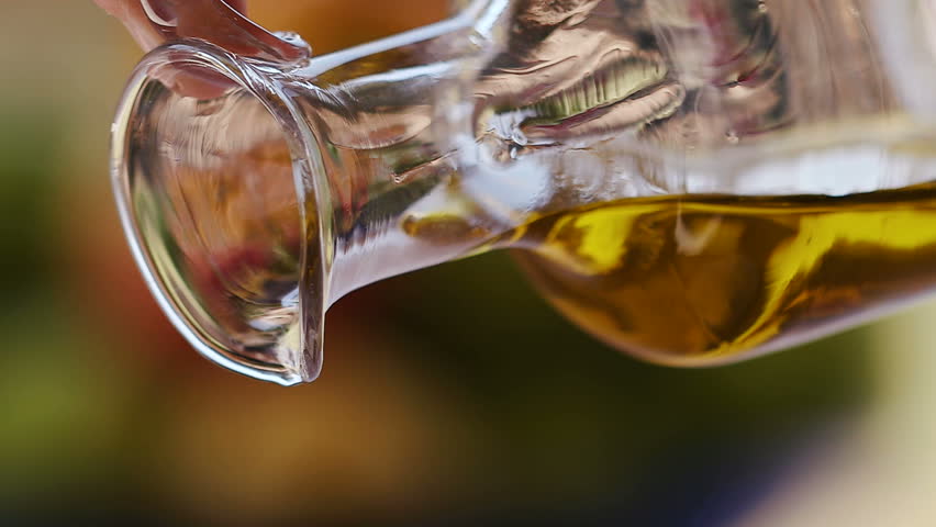 Slow motion shot of extra virgin olive oil being poured out a clear glass bottle Royalty-Free Stock Footage #19727977