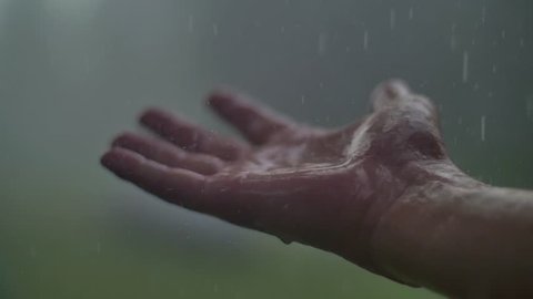 Man hand in the rain and hail