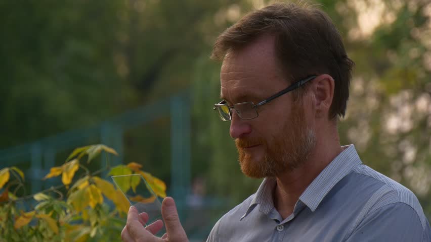 Adult Man Reading Jokes at Portable Virtual Tablet Computer. he Laughs After Their Perusal.