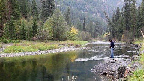 Young man fly fishing on a beautiful river in Montana