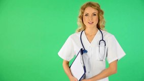 Beautiful nurse standing on green background