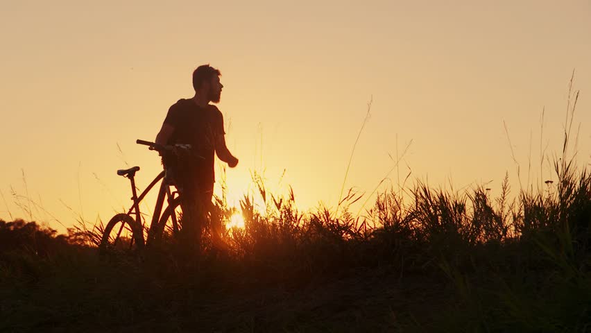 Bearded man with bike at sunset | Shutterstock HD Video #19757860