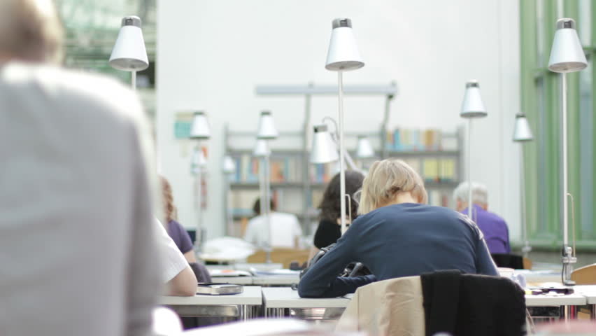 Student going through book pages in library