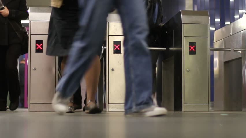 Passengers pass through subway turnstiles