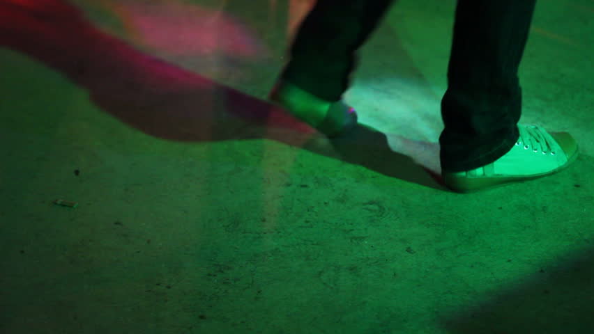 Man in sport shoes dance in club