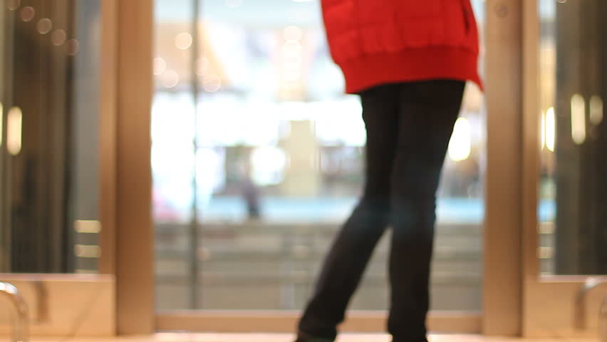 Woman awaits elevator in a shopping mall